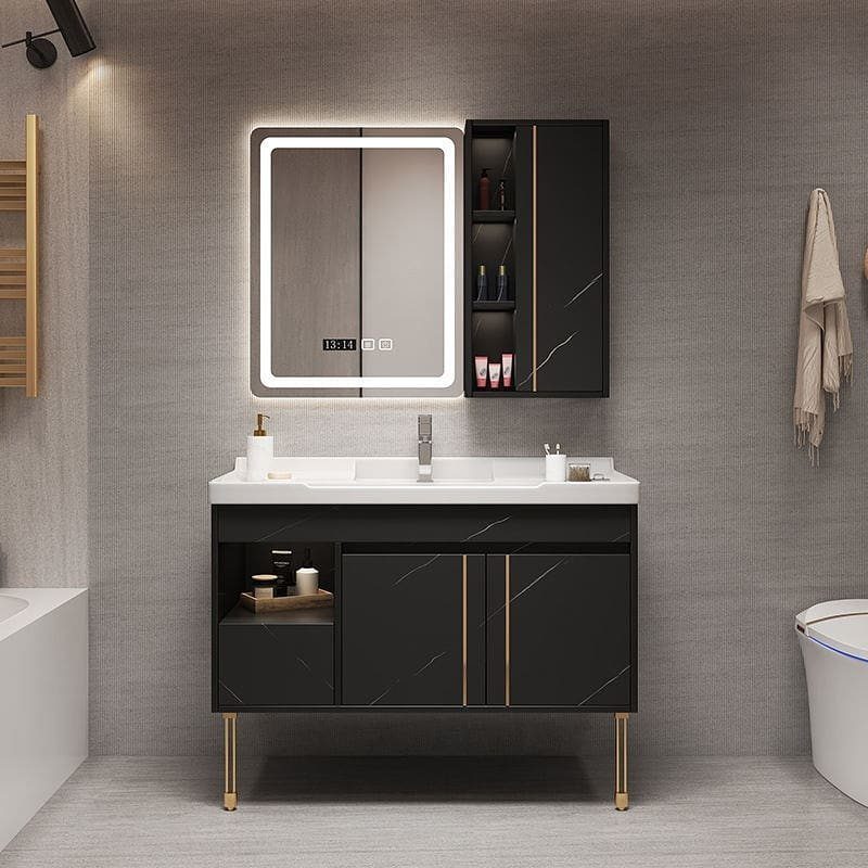 Black freestanding bathroom vanity with white countertop, gold legs, and open side shelving.