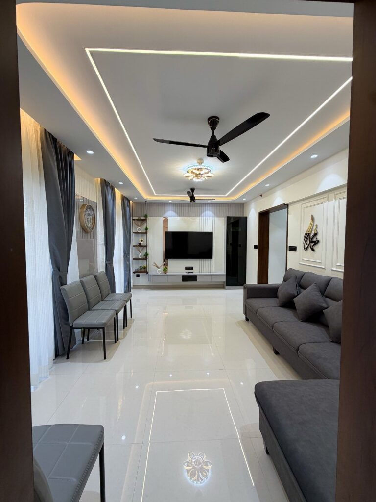 Modern living room with grey furniture, white glossy floors, and recessed ceiling lighting.