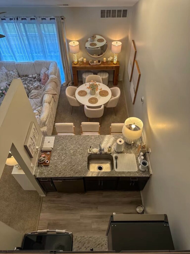 Open concept apartment interior with a kitchen, dining area, and large sliding glass windows.