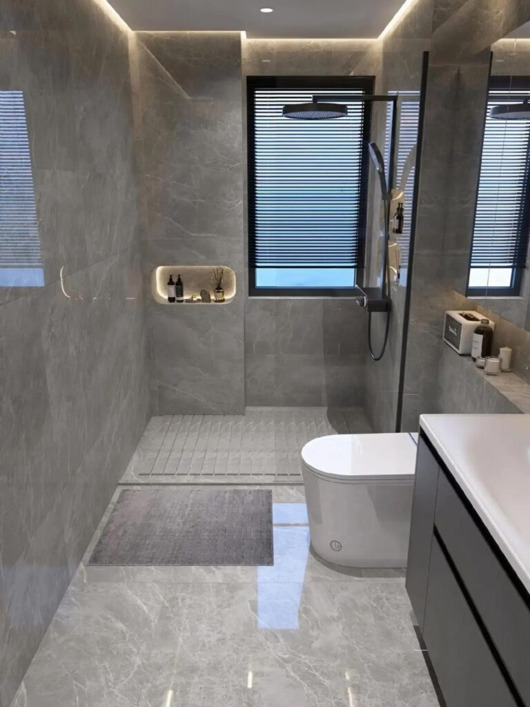 Modern bathroom with gray marble walls, white toilet, and dark gray vanity cabinetry.