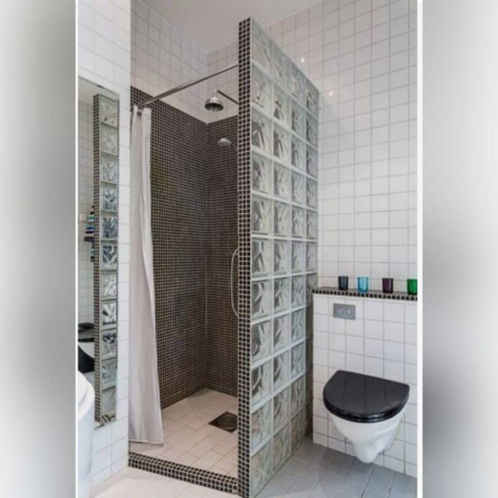 Modern bathroom with dark brown mosaic shower tiles and a glass block wall.