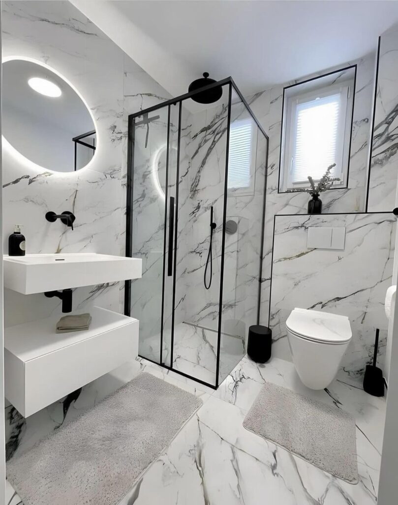Modern bathroom with white marble tile walls, black shower frame, and floating vanity.