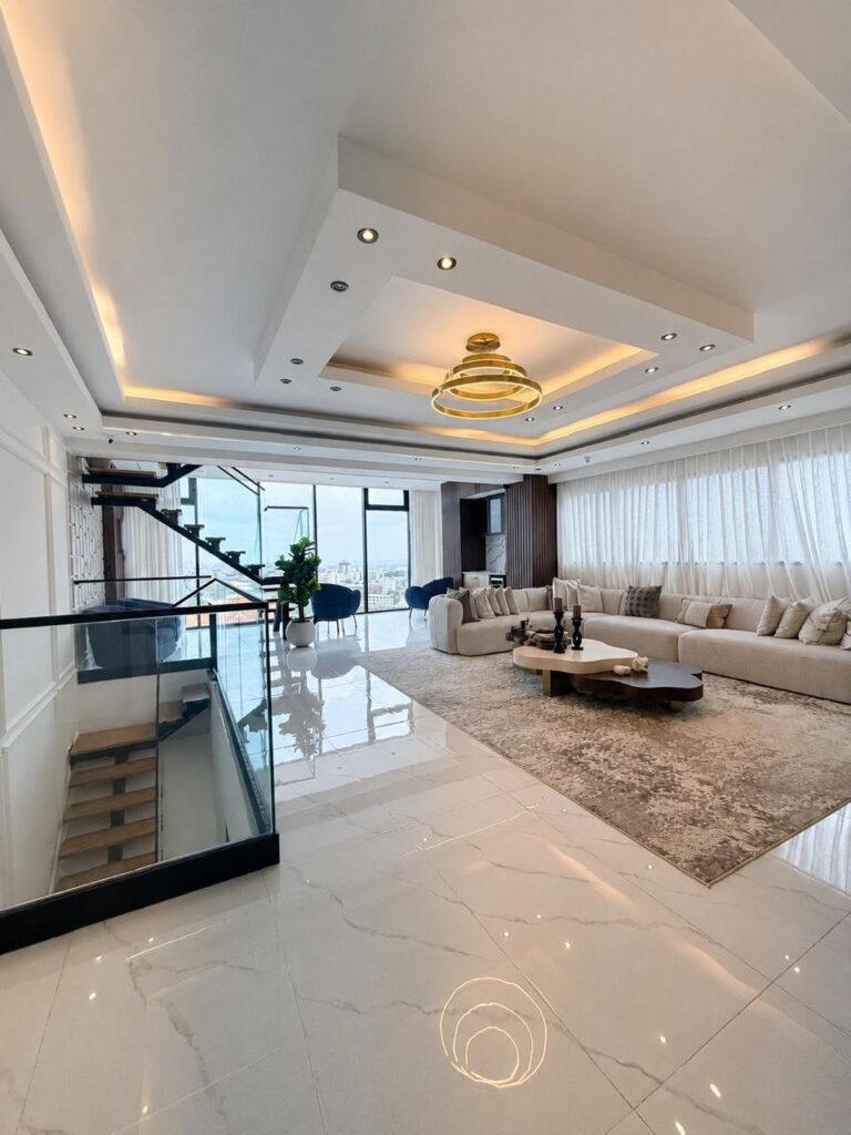 Modern luxury penthouse living room with white marble floors and city views.