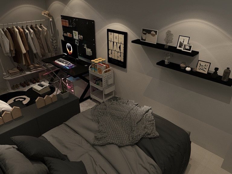 Small studio apartment featuring a grey bed, computer desk, and clothing rack.